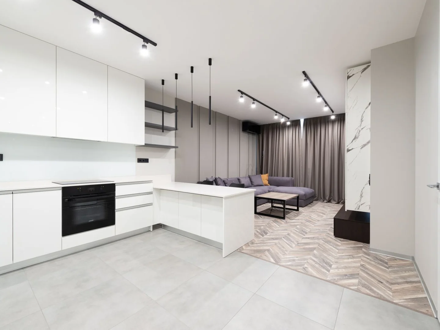 Black pendant fittings and slim dark furniture details in a pale open room.