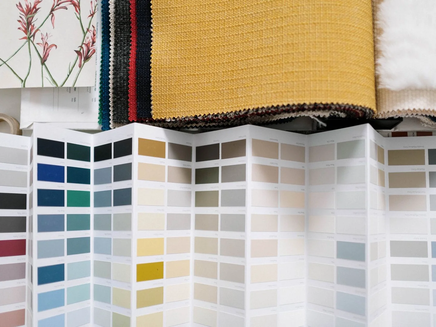 Fabric swatches and a fan of paint colours arranged together.