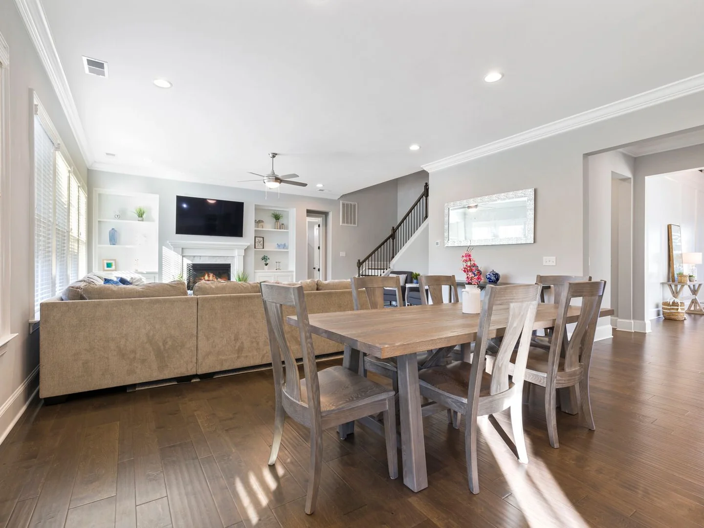 An open sitting and dining space using pale walls and related neutral furnishings.