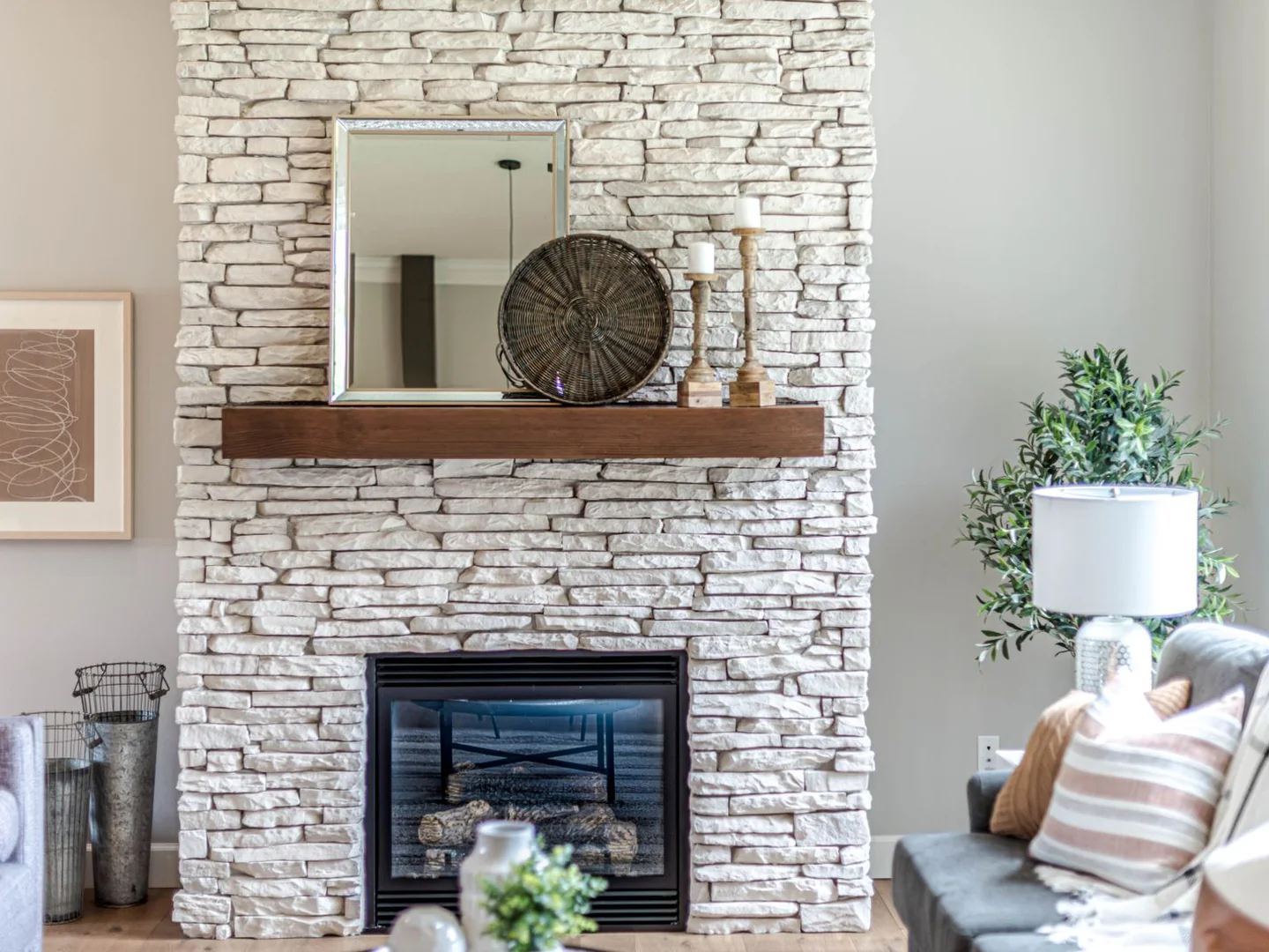 A projecting stone-clad chimney breast between living room furniture.