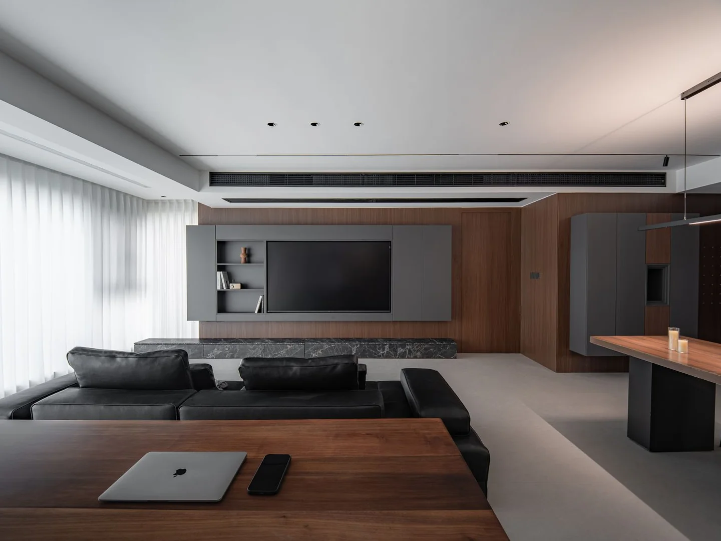 A long desk along one side of a living room.