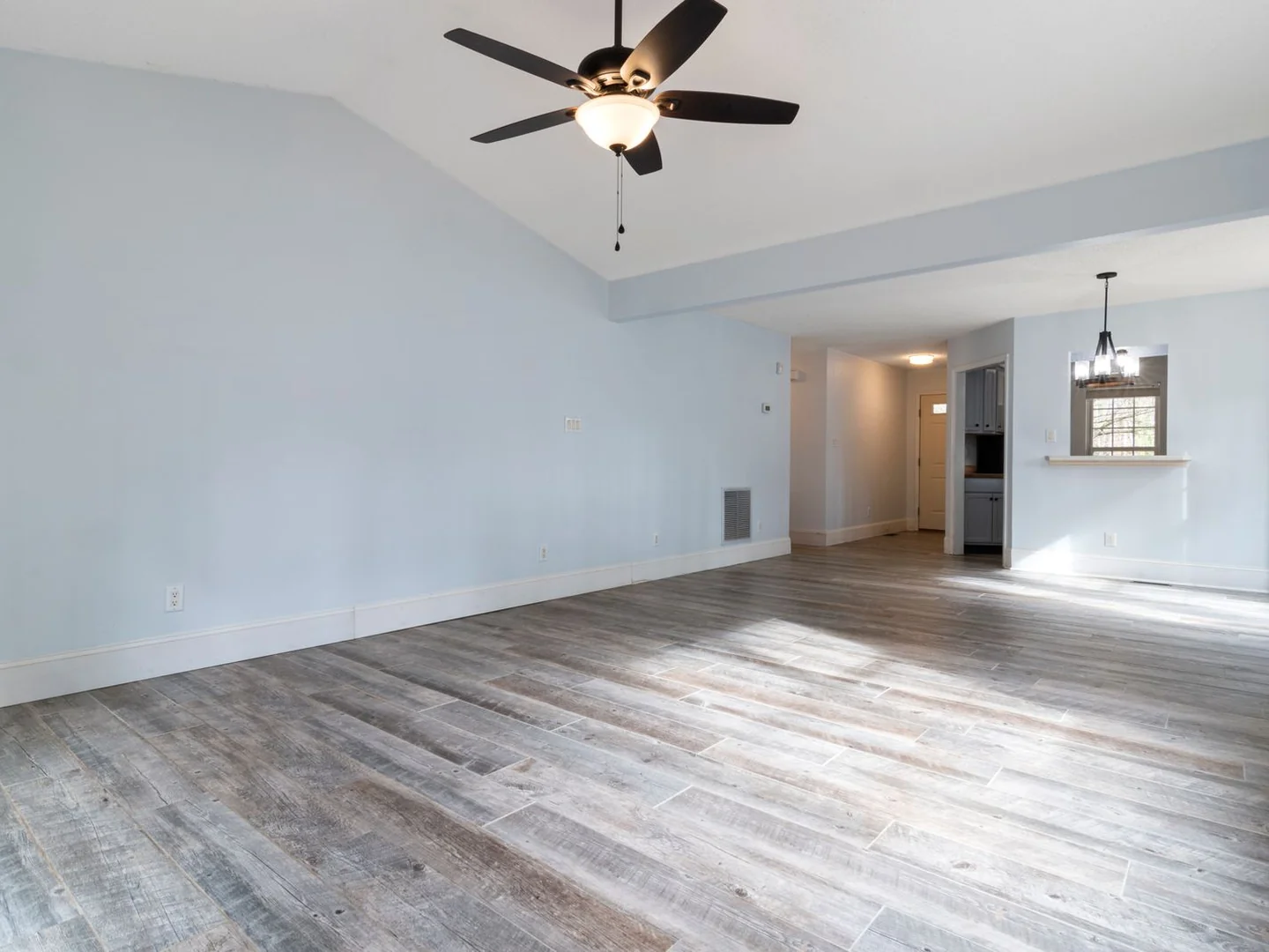 An empty living room showing its clear floor and corners.