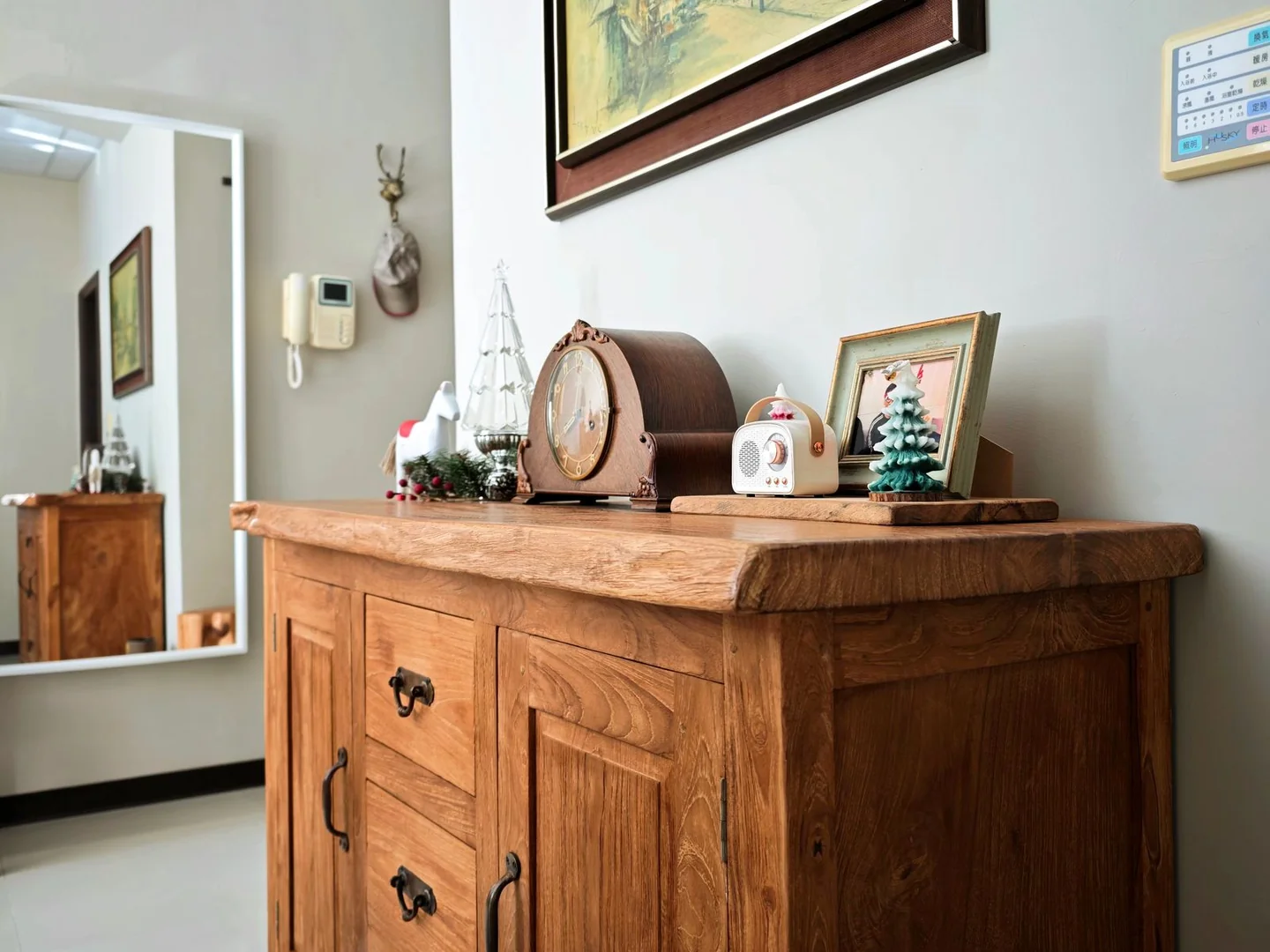 Small framed pictures resting on a wooden sideboard.