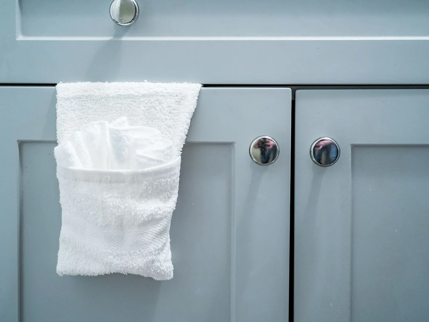 Closed bathroom cupboard doors with a folded towel.