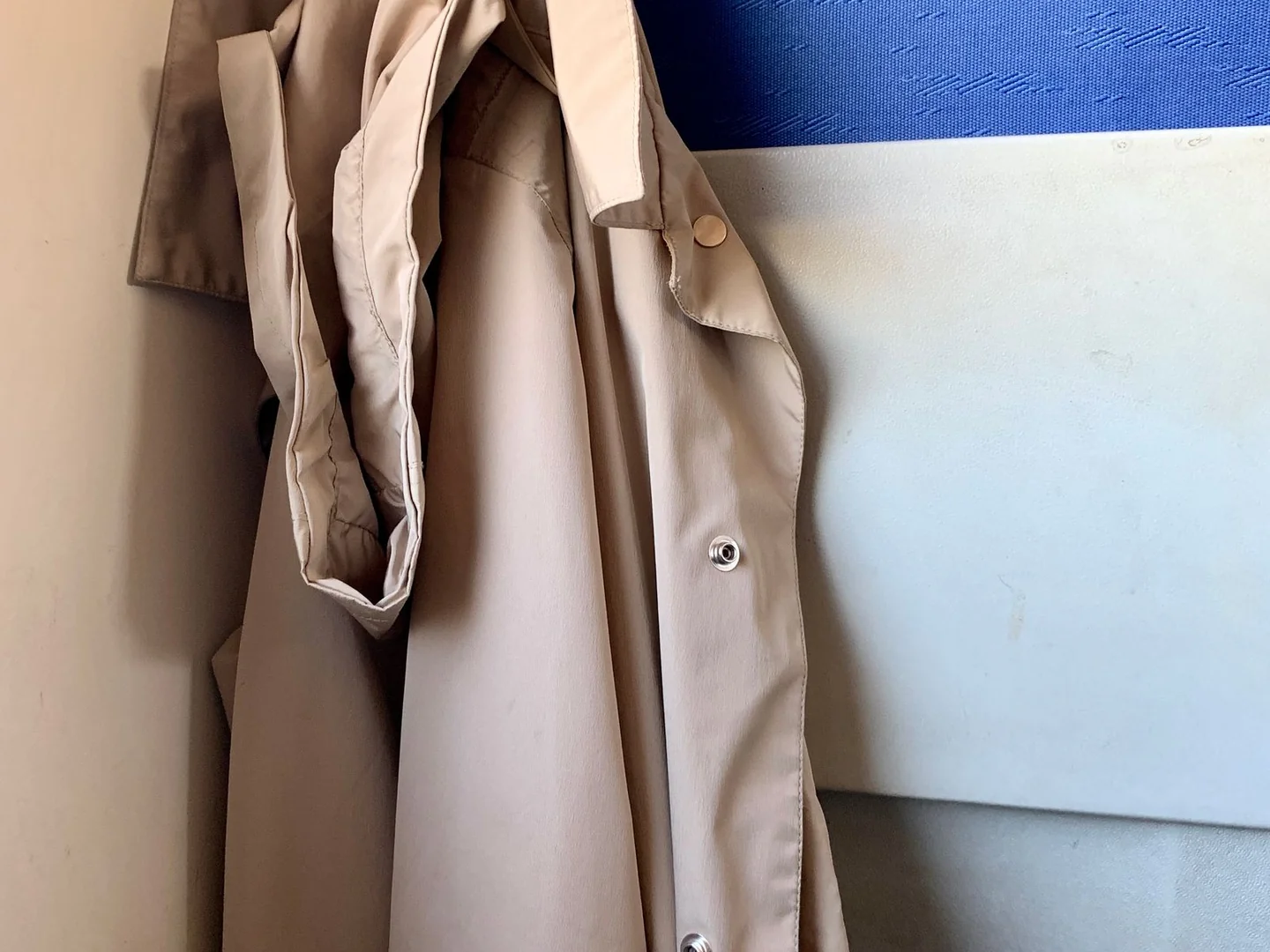 A coat hanging on a wall hook.