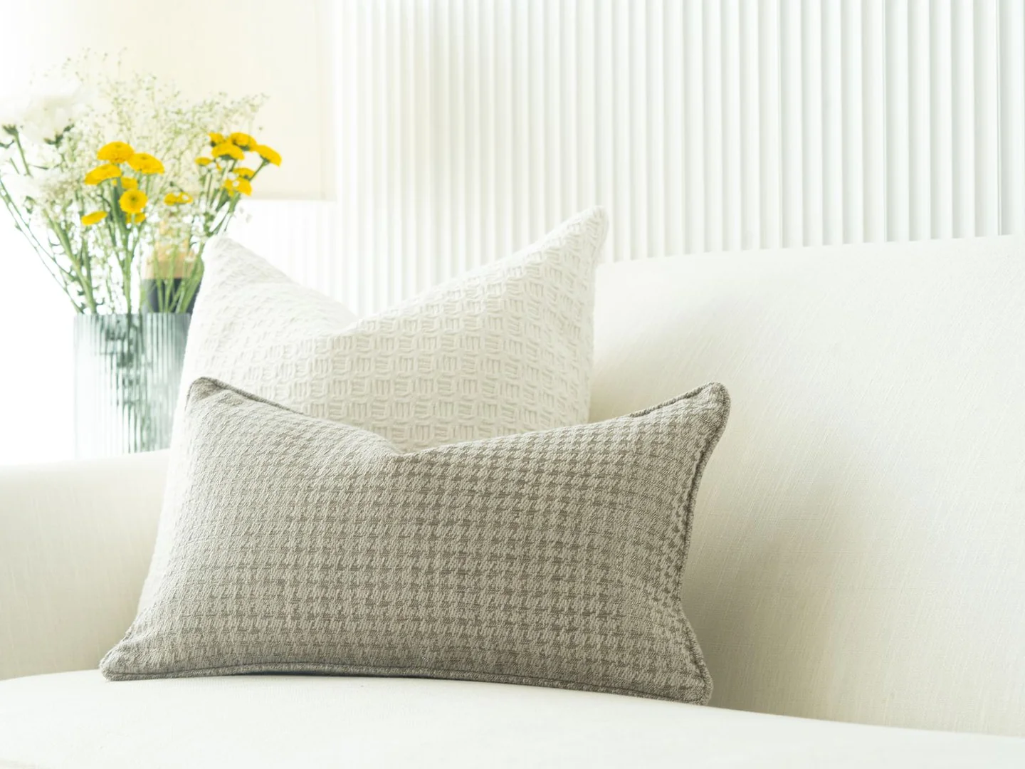 Small patterned cushions against a white sofa.