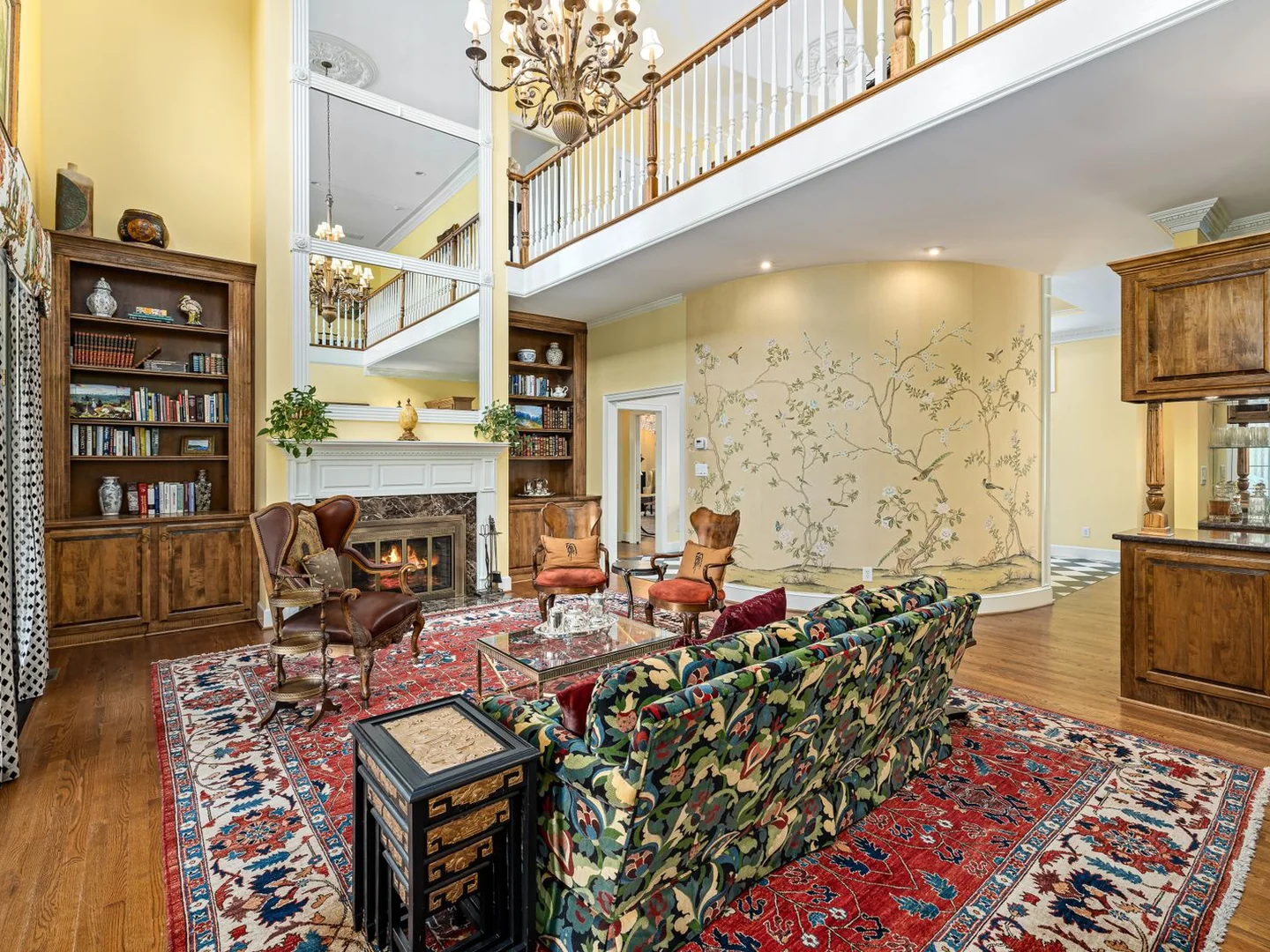 A patterned sofa and chairs arranged around a large living room rug.