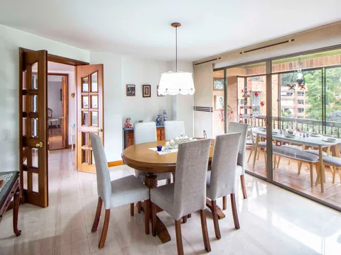 A pendant light positioned over a dining table with chairs.