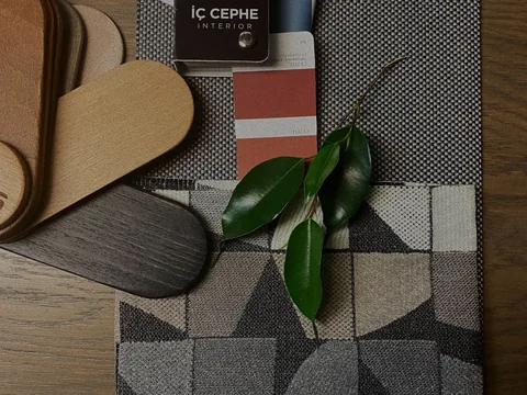 Fabric samples and colour cards laid out together on a table.
