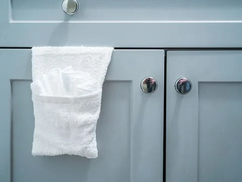 Closed bathroom cupboard doors with a folded towel.
