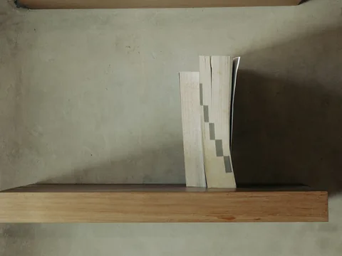 A floating timber shelf carrying a few books.