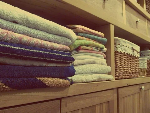 Folded towels grouped on cupboard shelves.