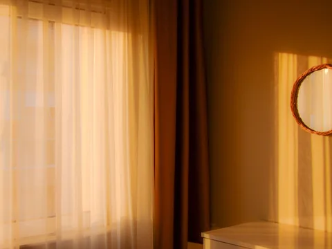 Warm-toned curtains beside a similarly coloured wall.
