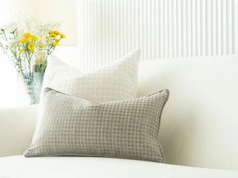 Small patterned cushions against a white sofa.